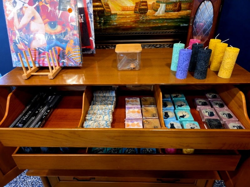 An open drawer of handmade candles and cat-themed soap bars