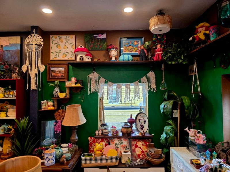 A green wall corner decorated with lemon prints and a mushroom house figurine