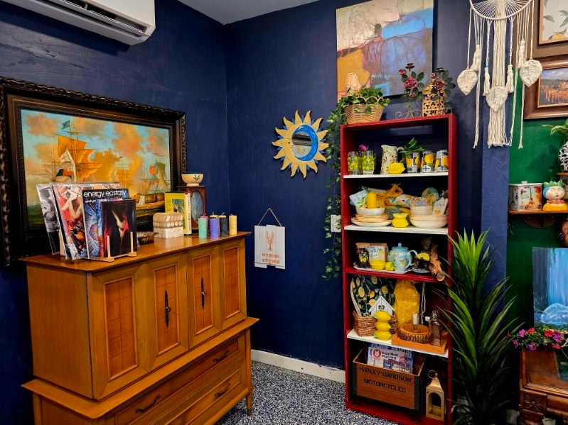 A nautical-themed corner with a ship painting and a red lemon-print shelf