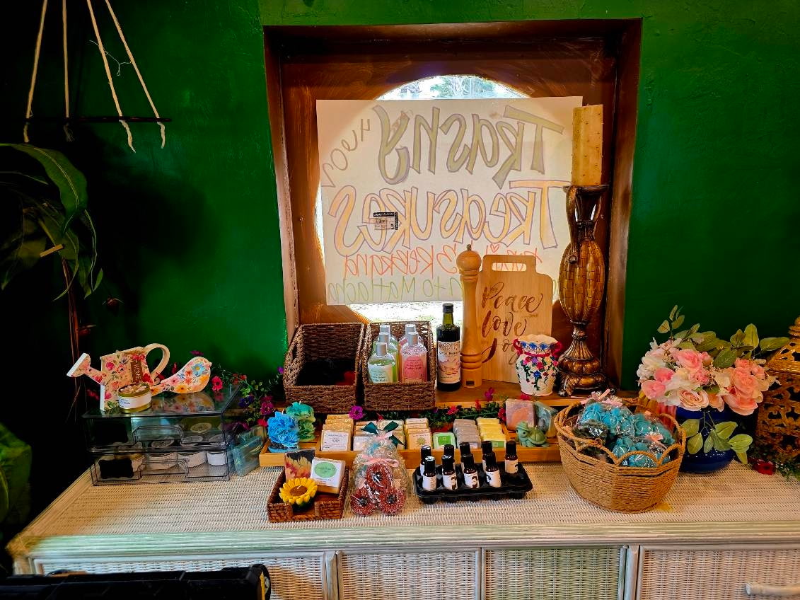 A handmade Trashy Treasures sign above a display of soaps and oils